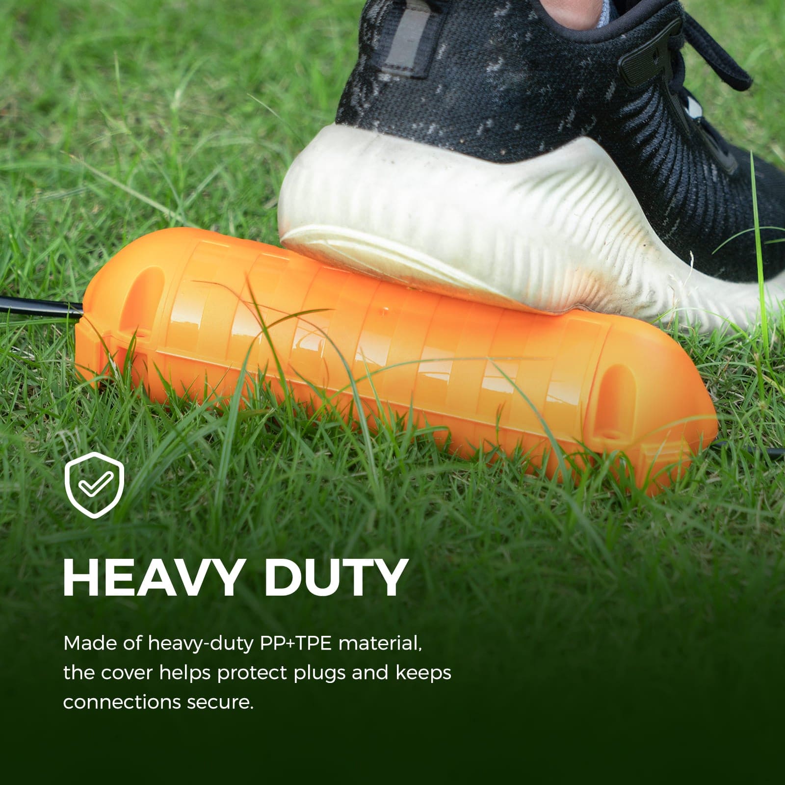 Accessory image for the WELKIN Extension Cord Cover (R1103). An orange, heavy-duty PP+TPE cover on grass being stepped on, emphasizing its durability and secure protection for plugs and connections.